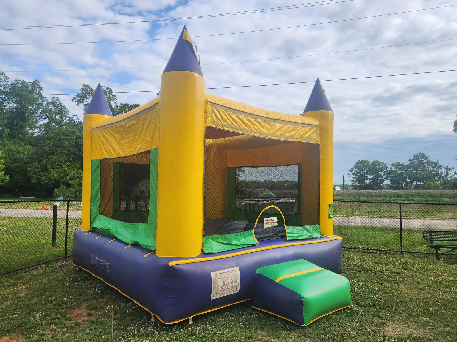 Wow Inflatables yellow and purple castle bounce house rental at outdoor event in Macon Georgia — classic castle inflatable for birthday parties