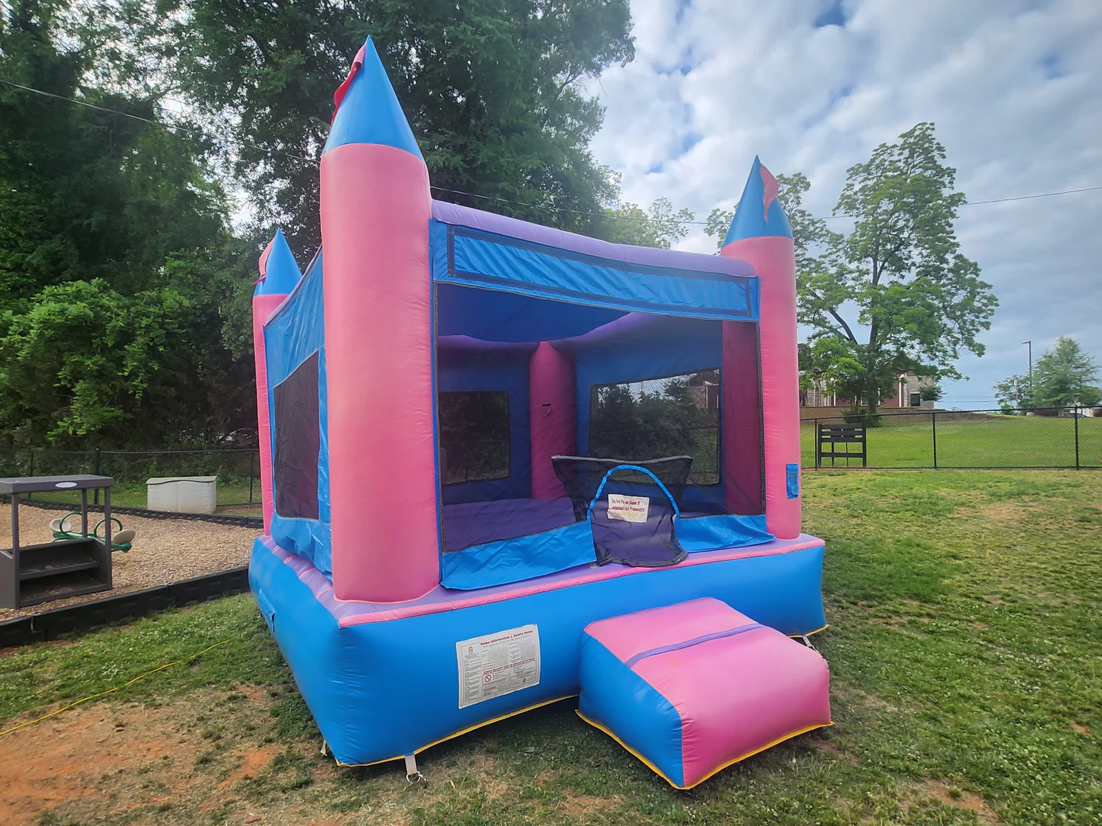 Wow Inflatables pink princess castle bounce house rental at outdoor birthday party in Macon Georgia — girls birthday party inflatable