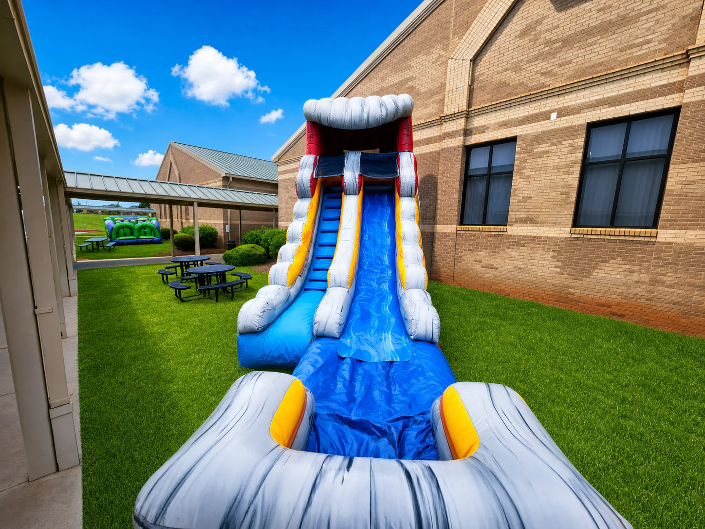 Wow Inflatables tall grey inflatable water slide rental angle view at outdoor event in Georgia — large water slide with splash pool