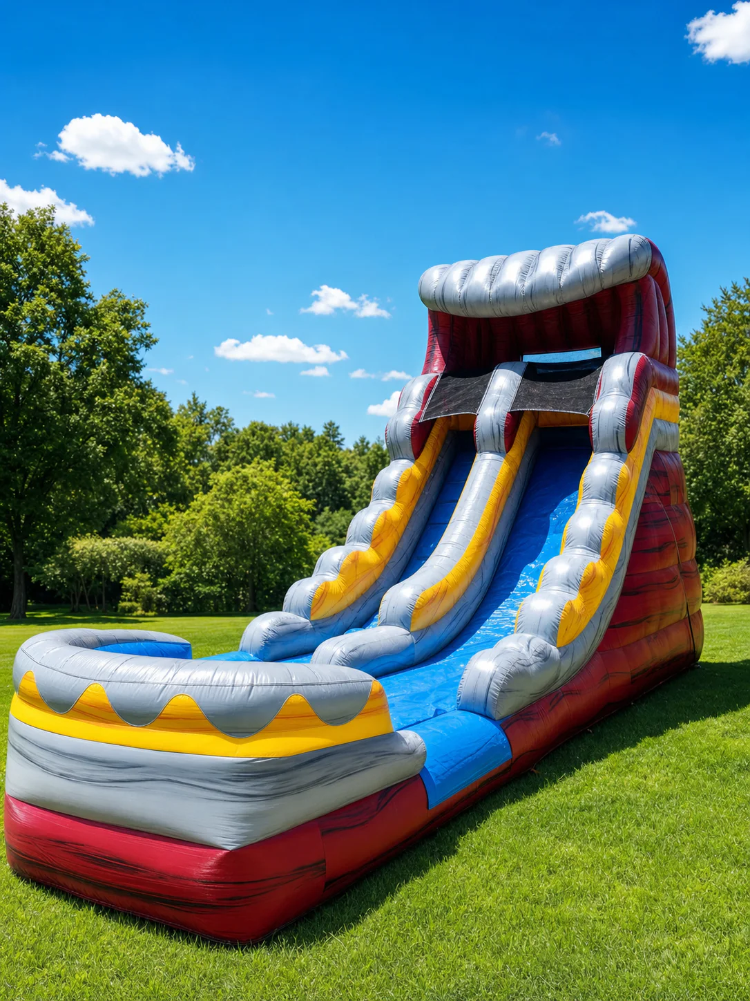 Wow Inflatables tall grey red and yellow inflatable water slide rental side view on green grass at outdoor summer event in Middle Georgia