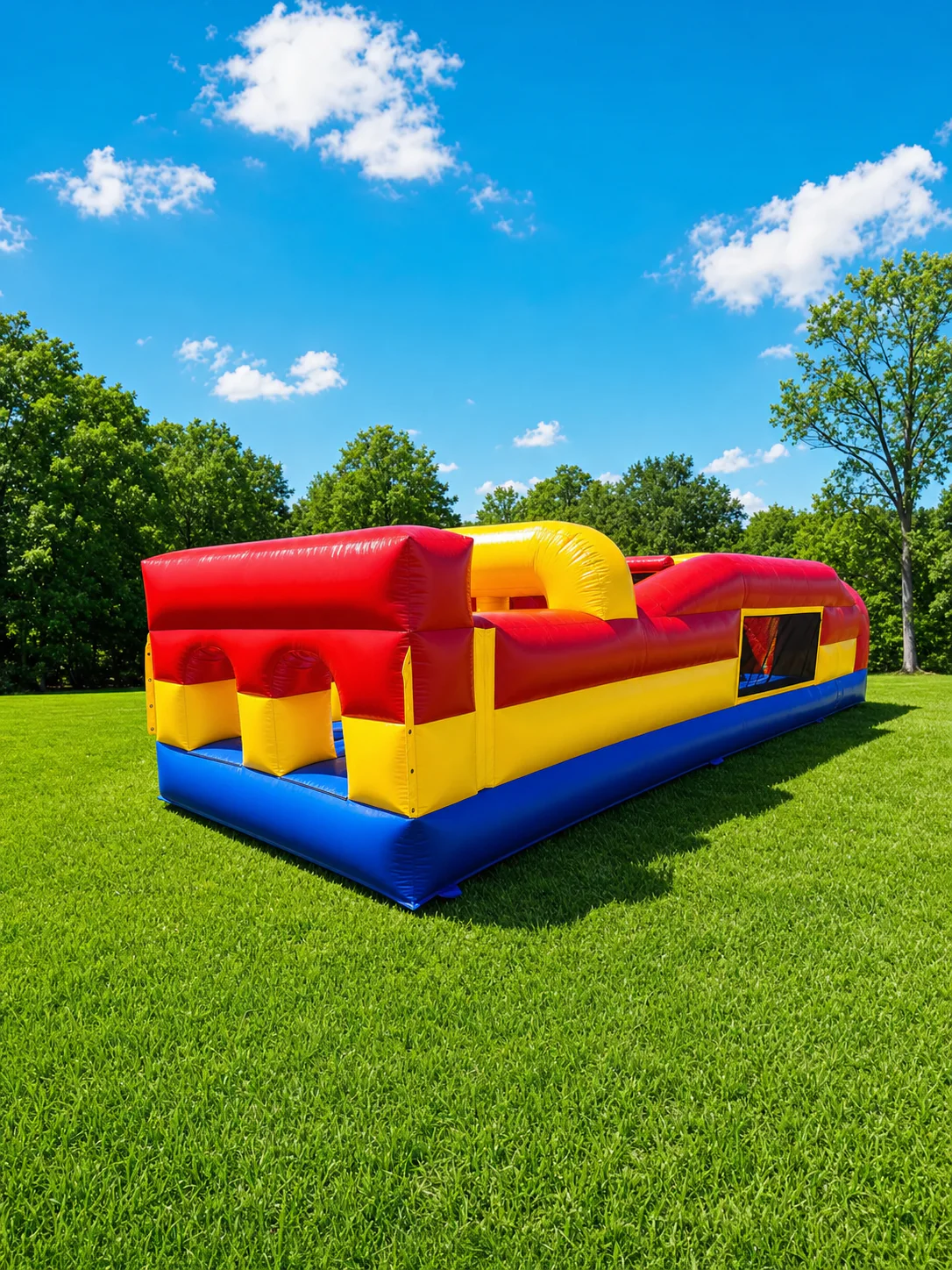 Wow Inflatables red yellow blue inflatable bungee run dual lane racing rental on green grass at outdoor event in Middle Georgia