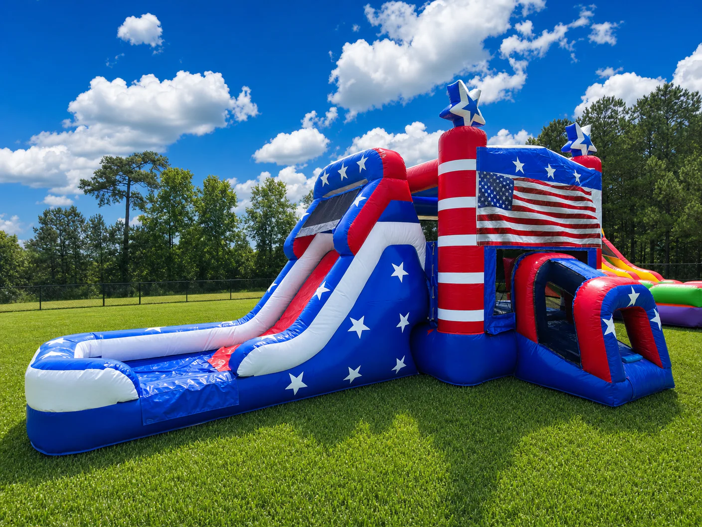 Wow Inflatables patriotic American flag inflatable combo bounce house with water slide rental featuring red white and blue colors white stars and American flag graphic on green grass in Forsyth Georgia — 4th of July inflatable rental