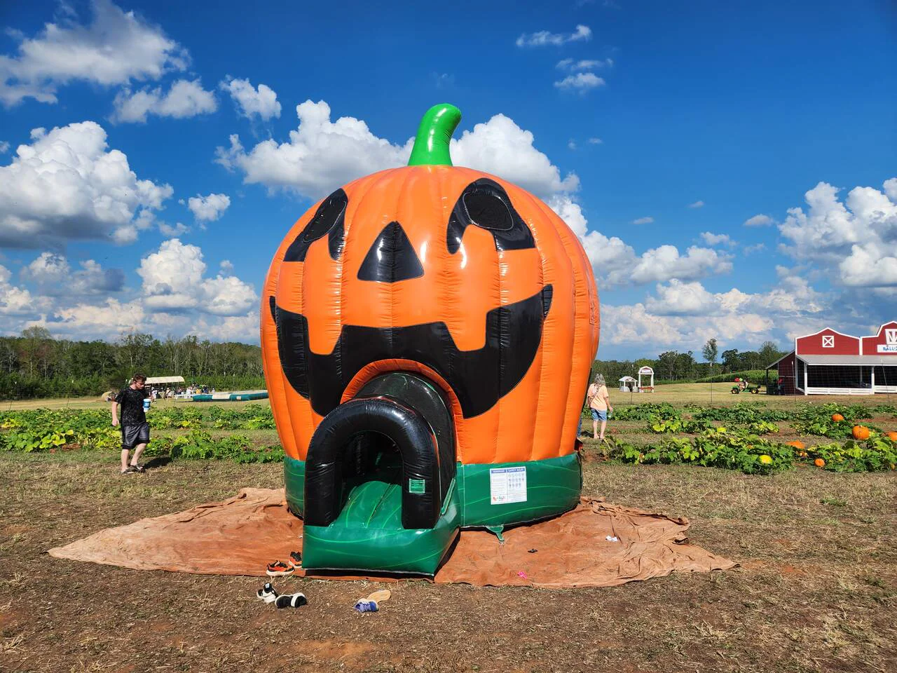 Wow Inflatables giant jack-o-lantern pumpkin bounce house rental at pumpkin patch in Georgia — orange inflatable pumpkin bounce house for Halloween and fall events