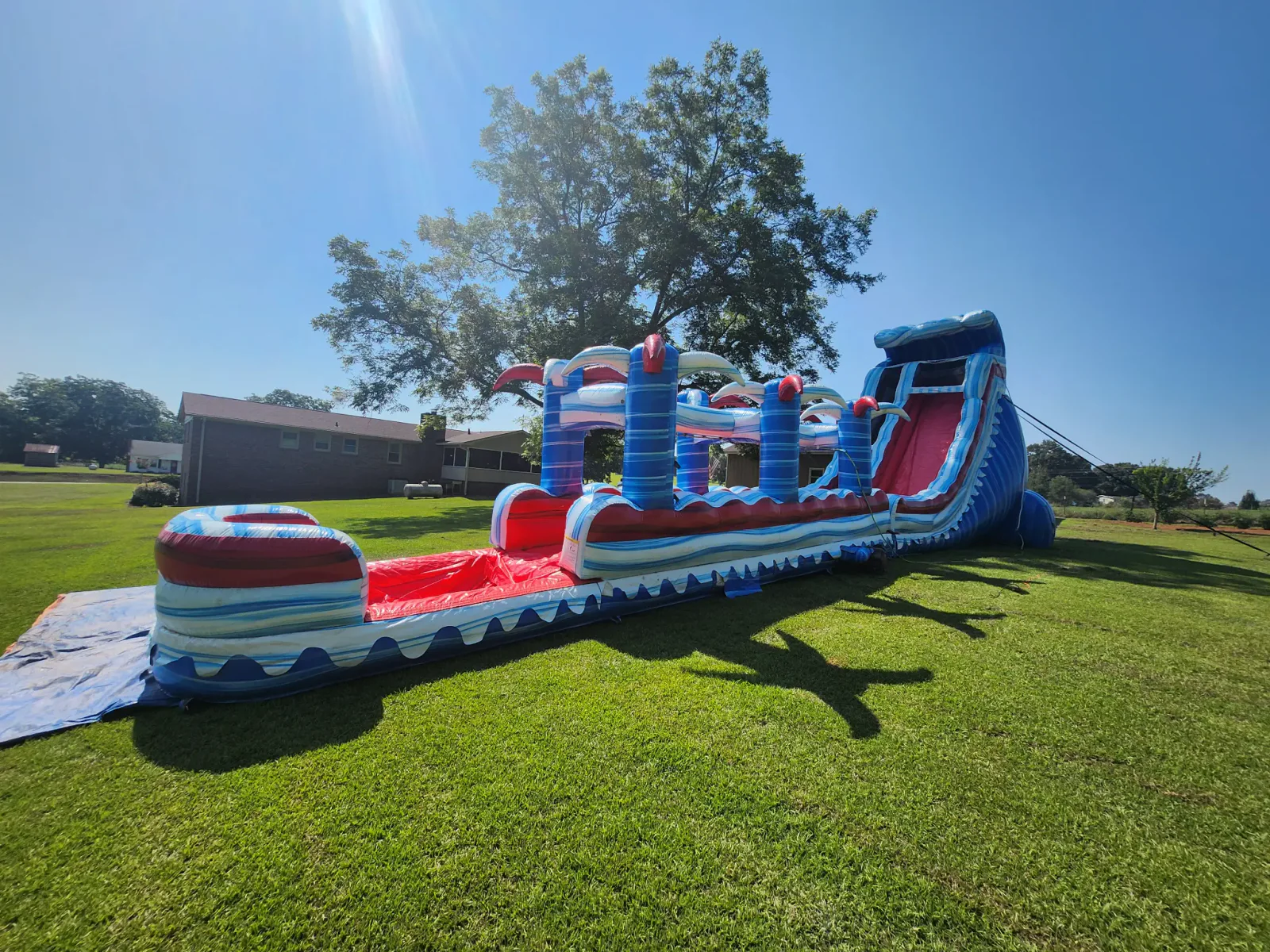 Wow Inflatables massive blue and red inflatable obstacle course with slide rental at outdoor event in Middle Georgia — 40-foot commercial obstacle course for teens and adults