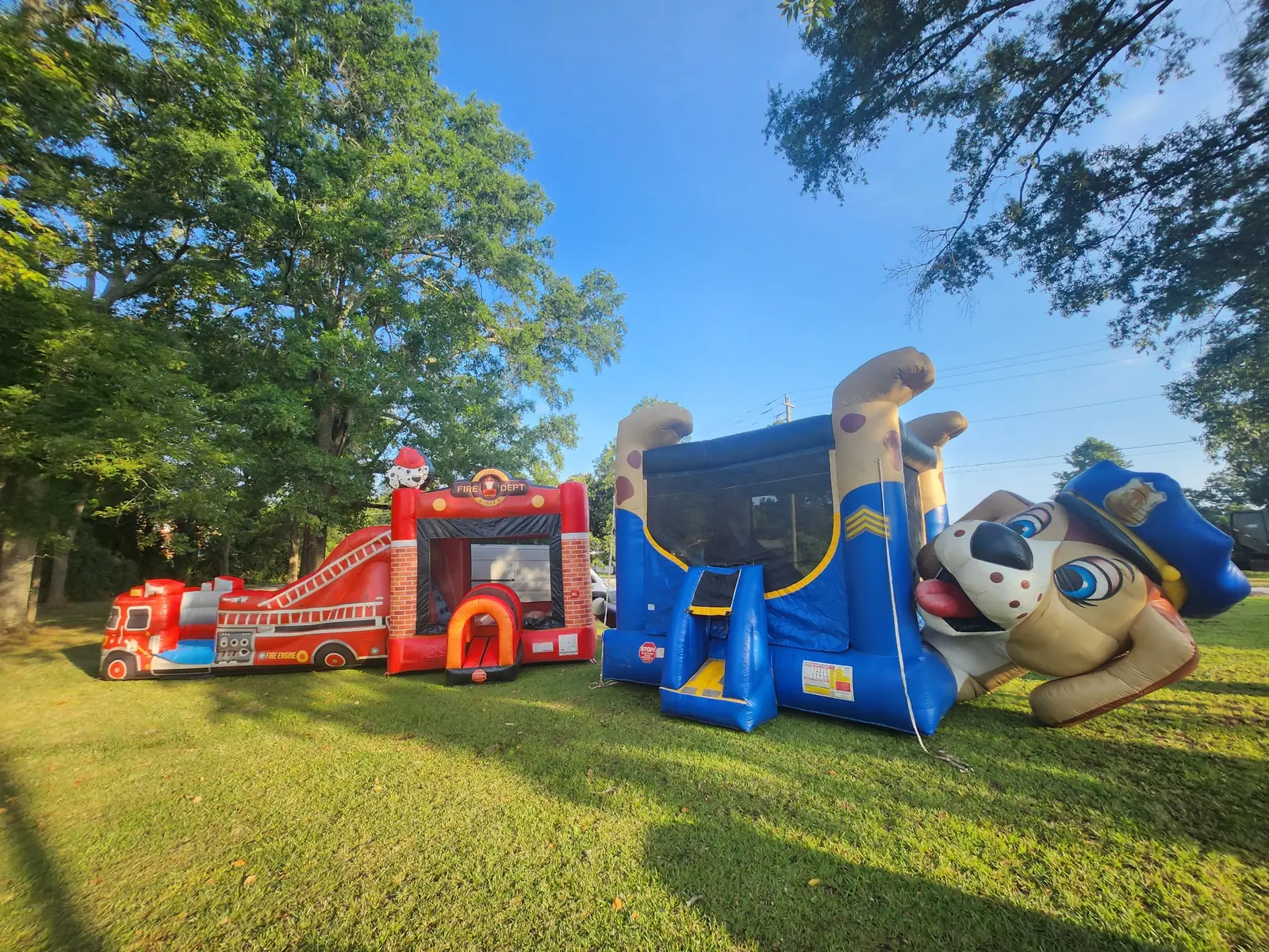 Owner-supplied event setup photo with fire truck and police dog themed inflatables available across Middle Georgia