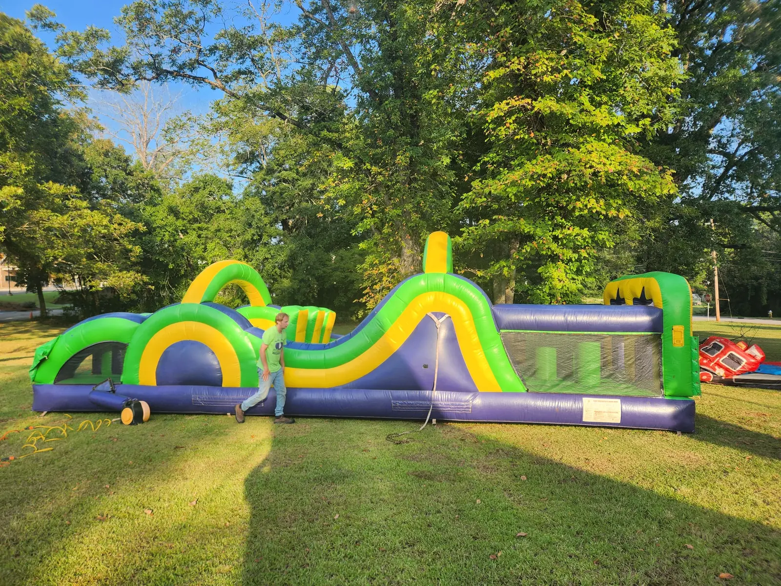 Owner-supplied photo of a long green yellow and purple inflatable obstacle course for Middle Georgia events