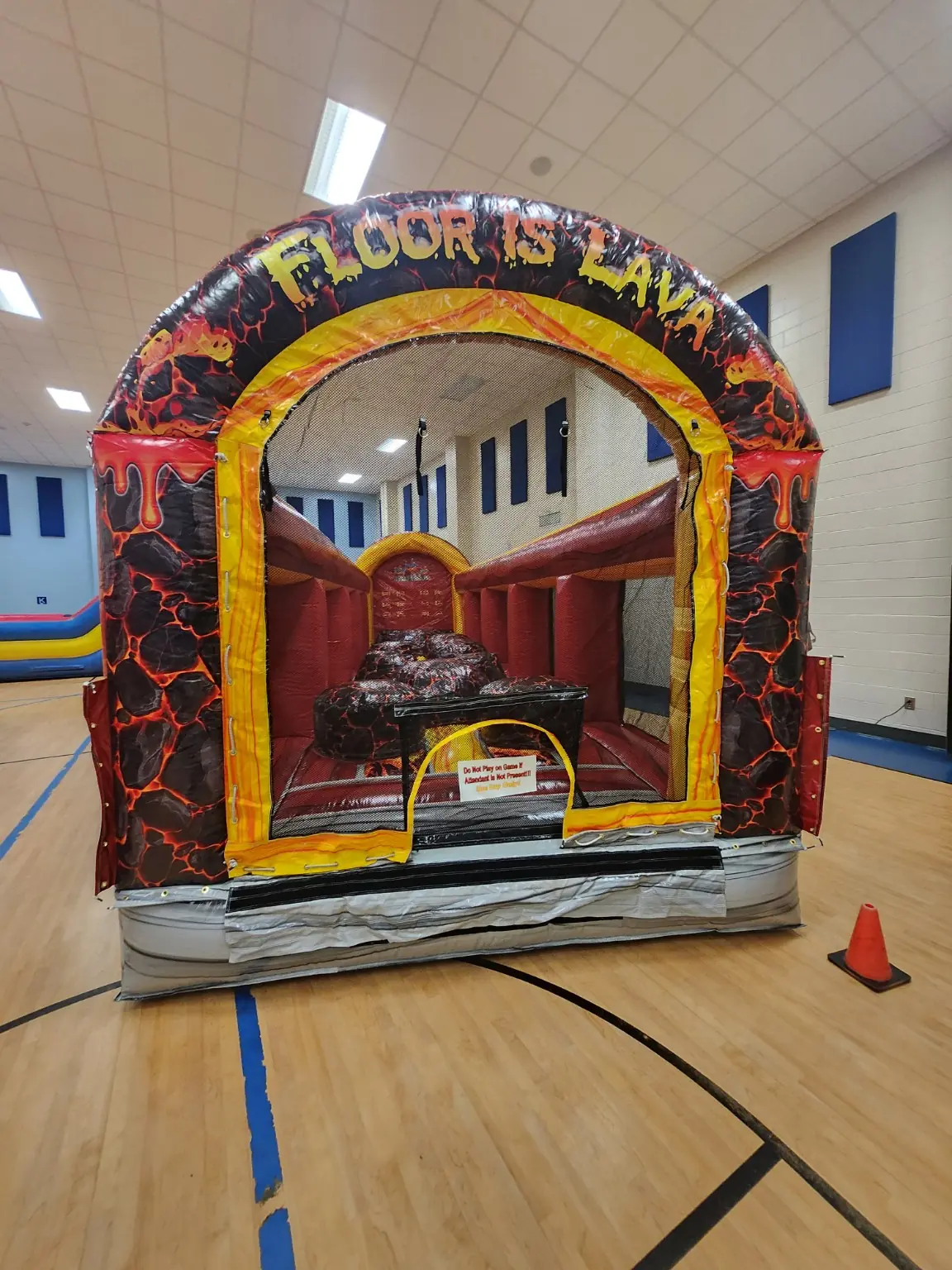 Front entrance of the Floor Is Lava inflatable obstacle course inside a gymnasium